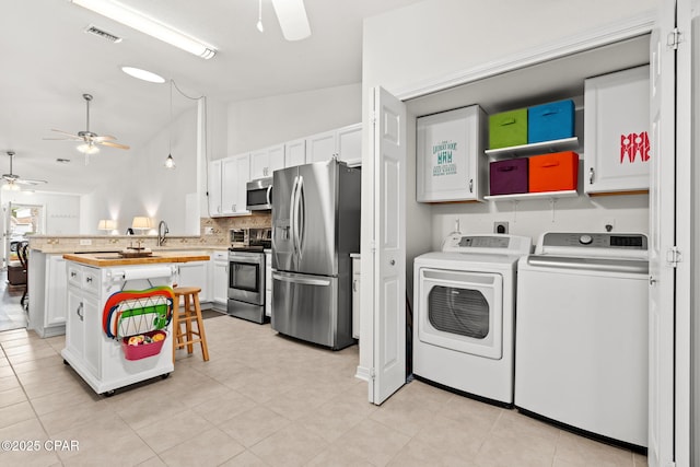 washroom featuring light tile patterned floors, washer and clothes dryer, and ceiling fan