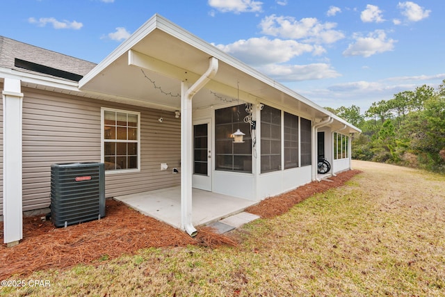 back of house with cooling unit, a yard, a sunroom, and a patio
