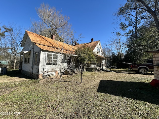 back of house featuring a lawn