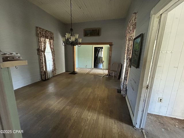 unfurnished dining area with dark hardwood / wood-style floors and a notable chandelier