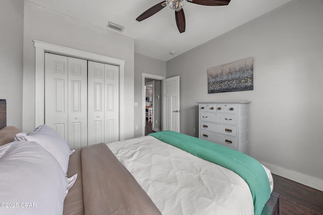 bedroom with a closet, dark hardwood / wood-style flooring, and ceiling fan