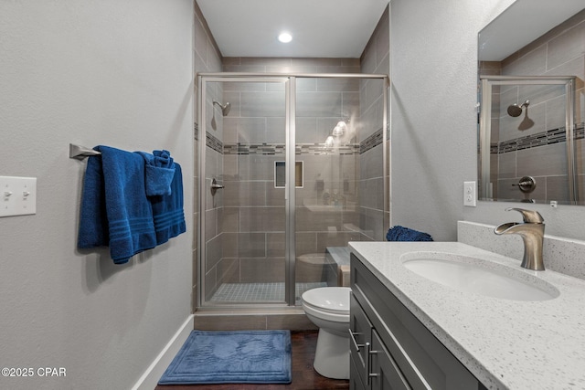 bathroom with hardwood / wood-style flooring, toilet, vanity, and an enclosed shower