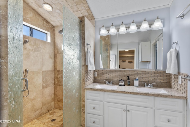 bathroom featuring vanity, tasteful backsplash, ornamental molding, vaulted ceiling, and a tile shower