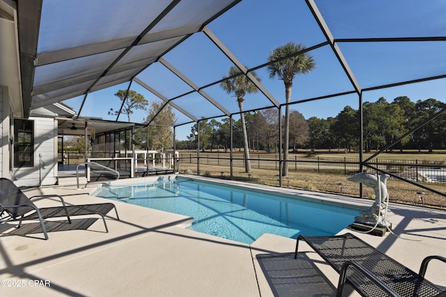 view of swimming pool featuring ceiling fan, a patio area, and glass enclosure