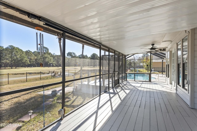 unfurnished sunroom with ceiling fan and a rural view