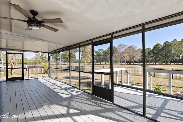 unfurnished sunroom featuring ceiling fan and plenty of natural light