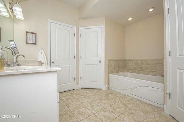 bathroom with tile patterned floors, a bath, and vanity