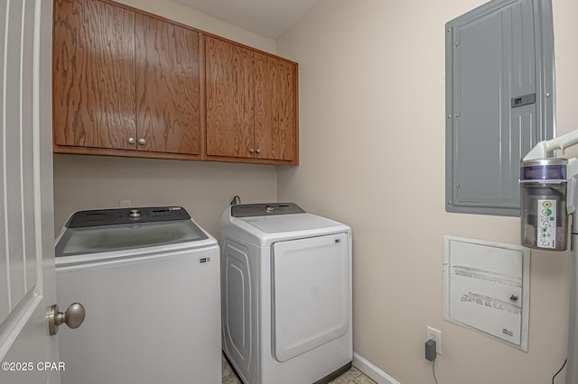 laundry room with cabinets, electric panel, and washing machine and dryer