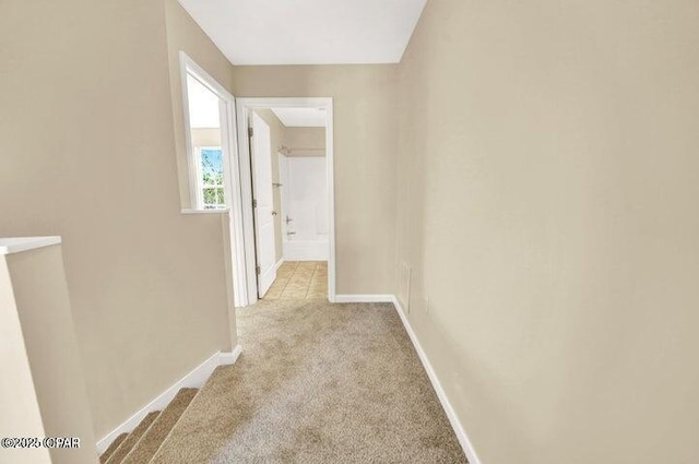 hall with light colored carpet