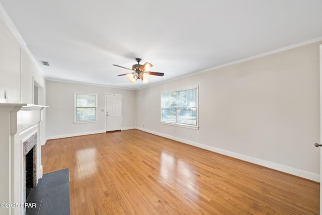 unfurnished living room with ceiling fan, ornamental molding, and light wood-type flooring