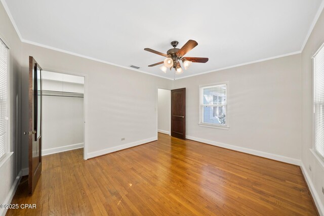 unfurnished bedroom featuring ceiling fan, hardwood / wood-style floors, a closet, and ornamental molding