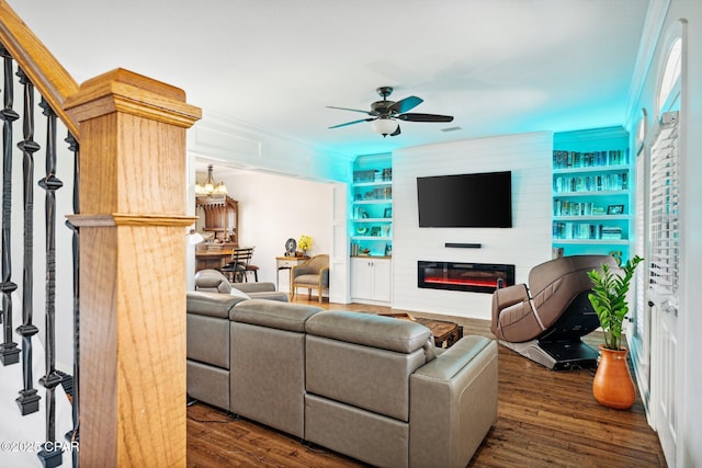 living room featuring ceiling fan, dark wood-type flooring, a fireplace, and built in shelves