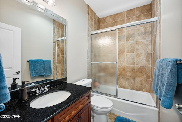 full bathroom with vanity, bath / shower combo with glass door, and toilet