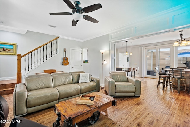 living room with crown molding, ceiling fan, and light wood-type flooring