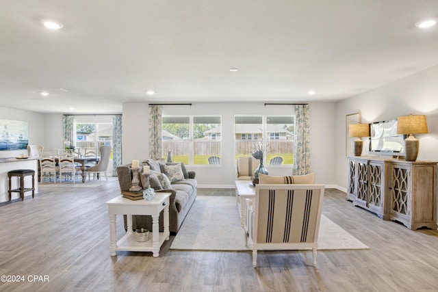 living area featuring light wood finished floors, baseboards, and recessed lighting