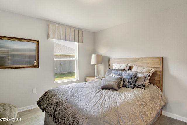 bedroom with wood finished floors and baseboards