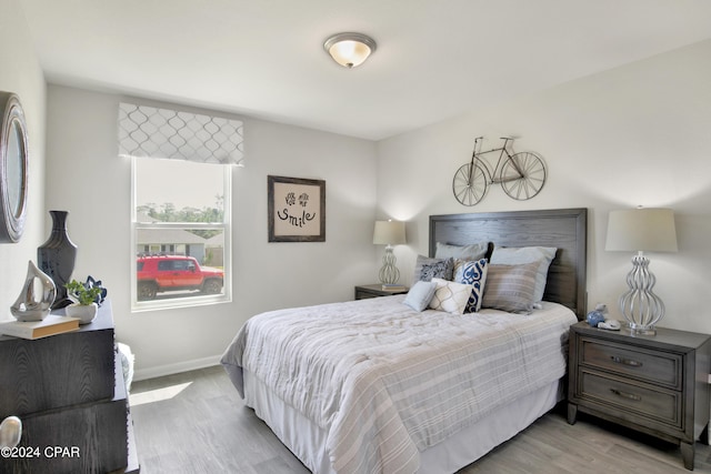 bedroom featuring light wood-style flooring and baseboards