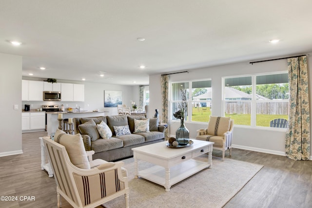 living room with baseboards, recessed lighting, and light wood-style floors