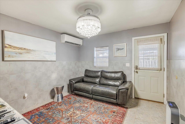 living room with an inviting chandelier, a wall mounted AC, tile walls, and light tile patterned floors