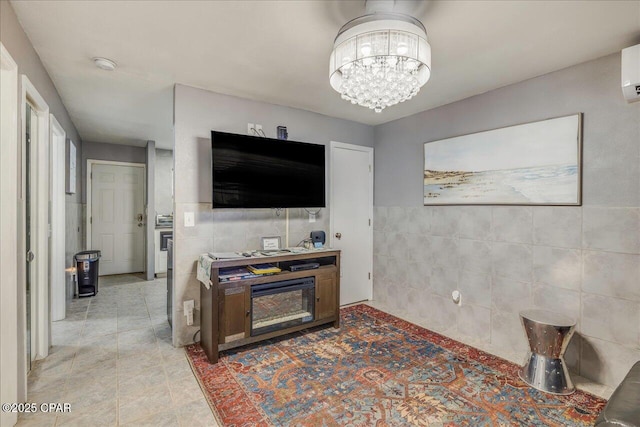 tiled living room with a wall mounted air conditioner, tile walls, and a chandelier