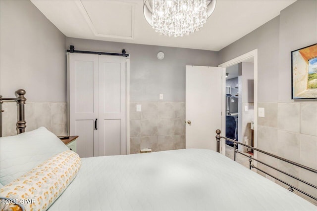 bedroom with tile walls, a closet, and a barn door