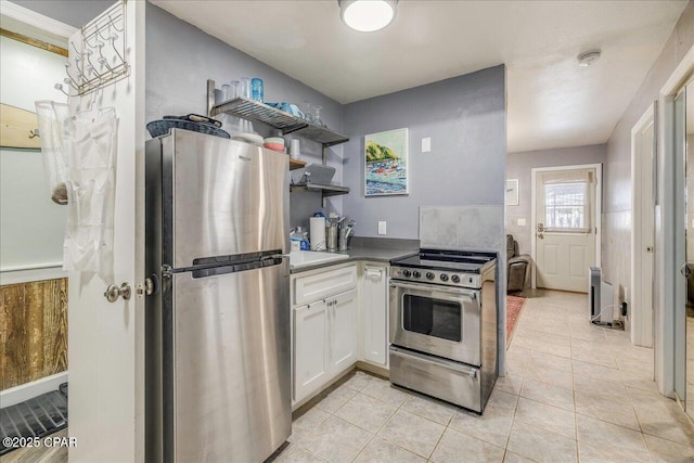 kitchen with white cabinetry, appliances with stainless steel finishes, light tile patterned flooring, and sink