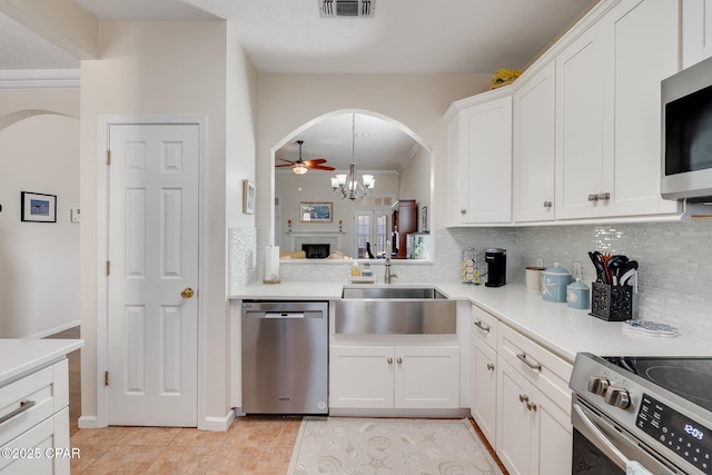 kitchen with light tile patterned floors, white cabinetry, stainless steel appliances, tasteful backsplash, and sink