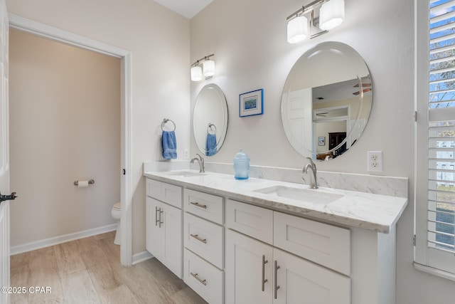 bathroom with toilet, a wealth of natural light, hardwood / wood-style flooring, and vanity