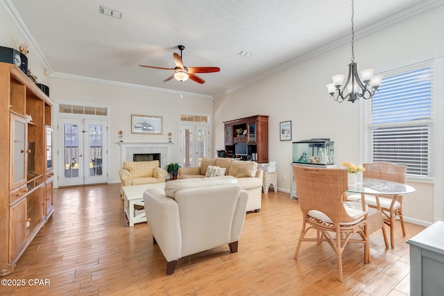 living room with light wood-type flooring, french doors, plenty of natural light, and crown molding