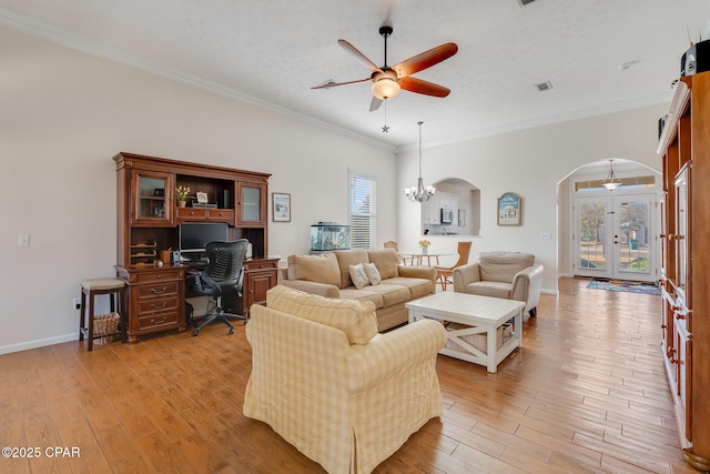 living room with a textured ceiling, ornamental molding, french doors, and light wood-type flooring