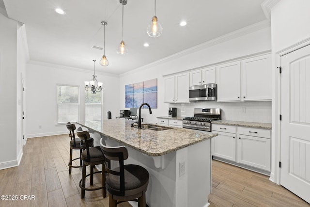 kitchen with backsplash, ornamental molding, stainless steel appliances, and a sink