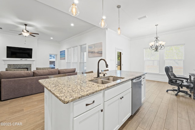 kitchen with a fireplace, visible vents, a sink, light wood-type flooring, and dishwasher