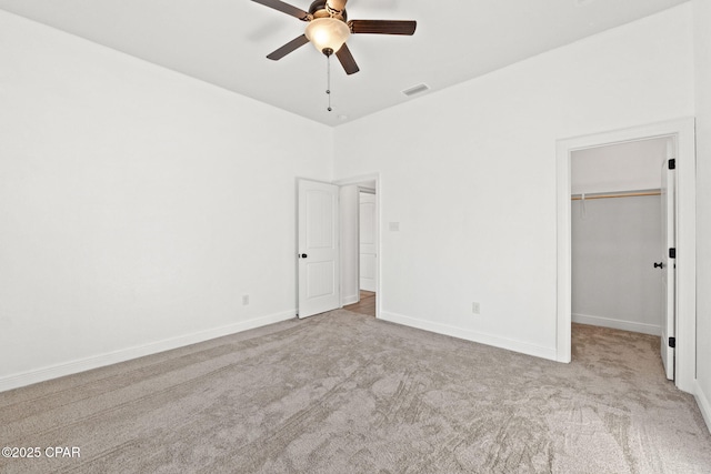 unfurnished bedroom featuring carpet flooring, visible vents, baseboards, a spacious closet, and a closet