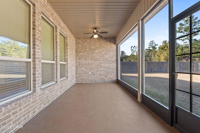 unfurnished sunroom with a ceiling fan