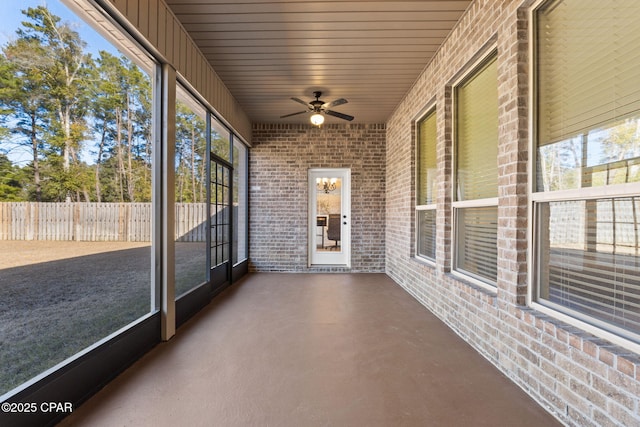 unfurnished sunroom with ceiling fan