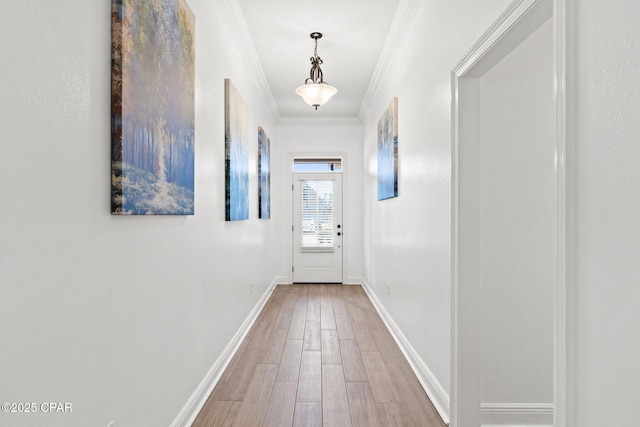 doorway with crown molding, baseboards, and wood finished floors