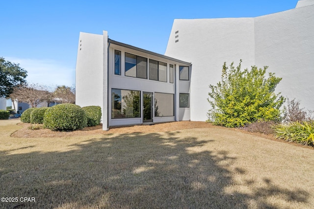 back of property featuring a lawn