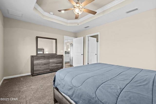 bedroom featuring ceiling fan, ornamental molding, a tray ceiling, and carpet floors