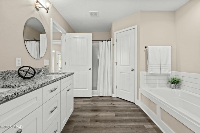 bathroom featuring a bath, vanity, and hardwood / wood-style floors