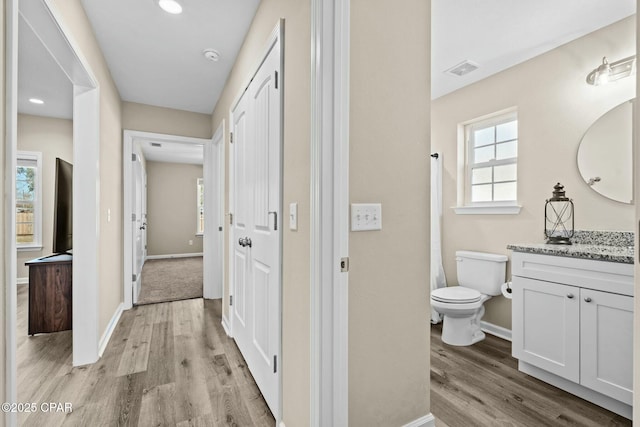 bathroom with hardwood / wood-style flooring, vanity, and toilet