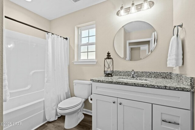 full bathroom featuring vanity, hardwood / wood-style flooring, toilet, and shower / bath combo