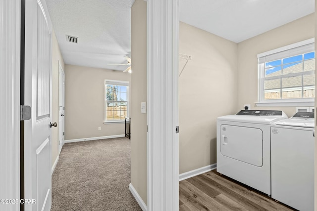 laundry room with separate washer and dryer, light carpet, and ceiling fan