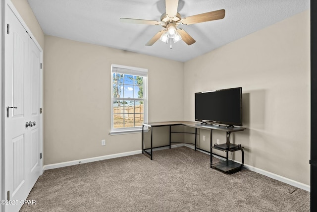 carpeted office space featuring ceiling fan