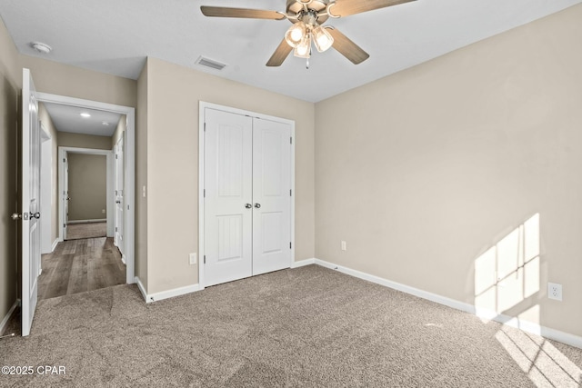 unfurnished bedroom with carpet flooring, ceiling fan, and a closet