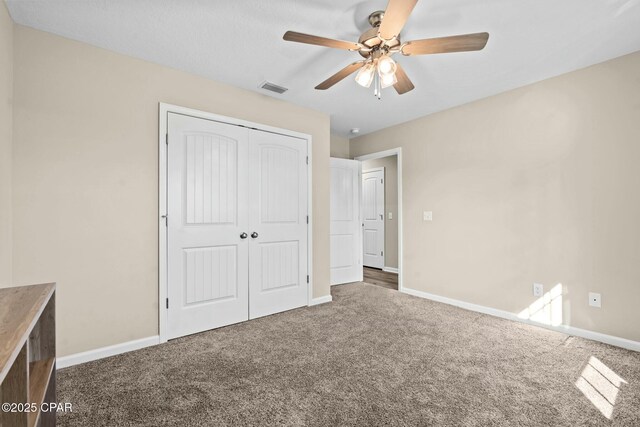 unfurnished bedroom featuring a closet, ceiling fan, and carpet