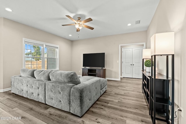 living room featuring ceiling fan and light hardwood / wood-style floors