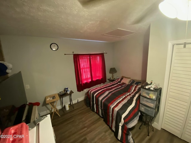 bedroom featuring a textured ceiling and dark hardwood / wood-style floors