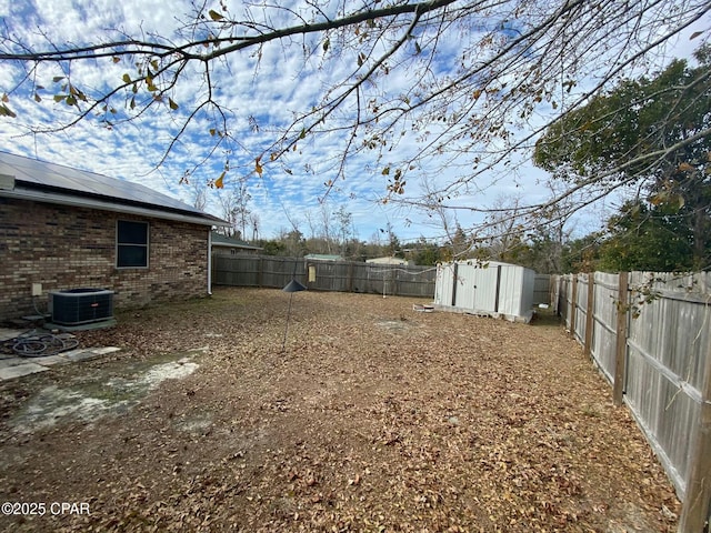 view of yard featuring central air condition unit and a storage shed