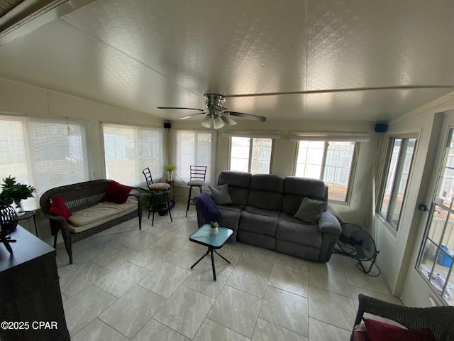 living room featuring vaulted ceiling, ceiling fan, and a textured ceiling