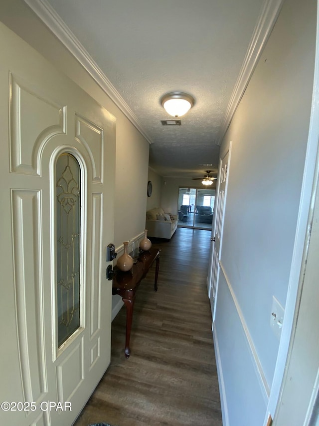 hall with ornamental molding, dark hardwood / wood-style floors, and a textured ceiling